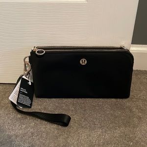 Lululemon curved wristlet. Brand new. Still has the tag. Black in color. Leather